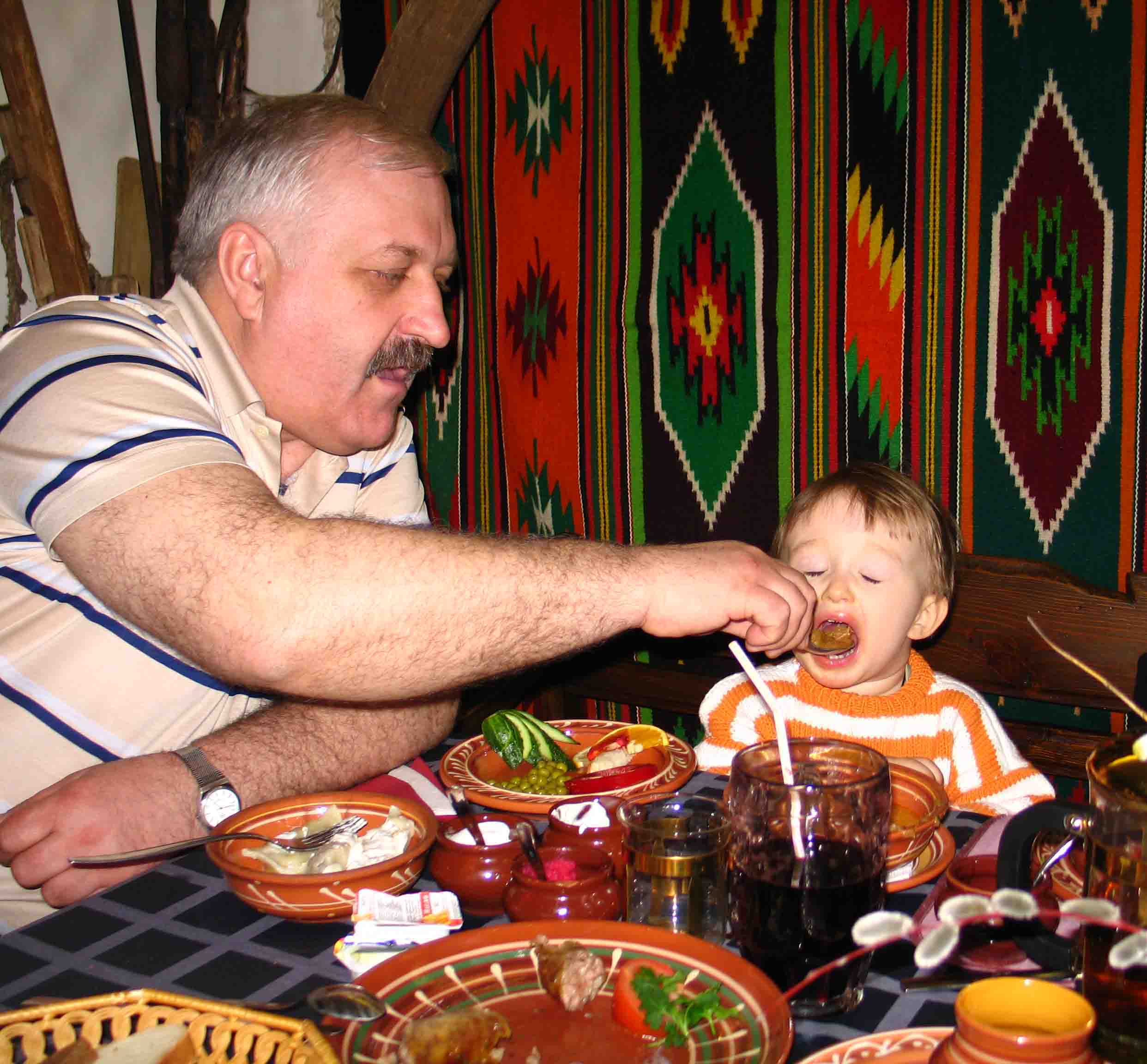 Внучка есть у дедушки. Дед за столом. Дедушка и внук. Дедушка кормит внучку. Бабушка дедушка внуки кушают.
