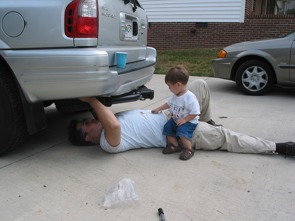 Дети под машину. Папа чинит машину. Мальчик чинит машину. Папа под машиной.