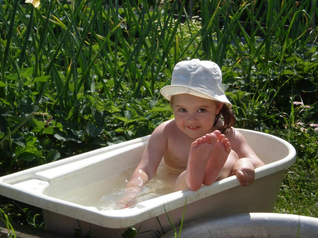 Дочка купается в ванне. Девочка в бассейне на даче. Купание детей в бассейне на даче. Малыши на даче. Маленькие детки купаются.