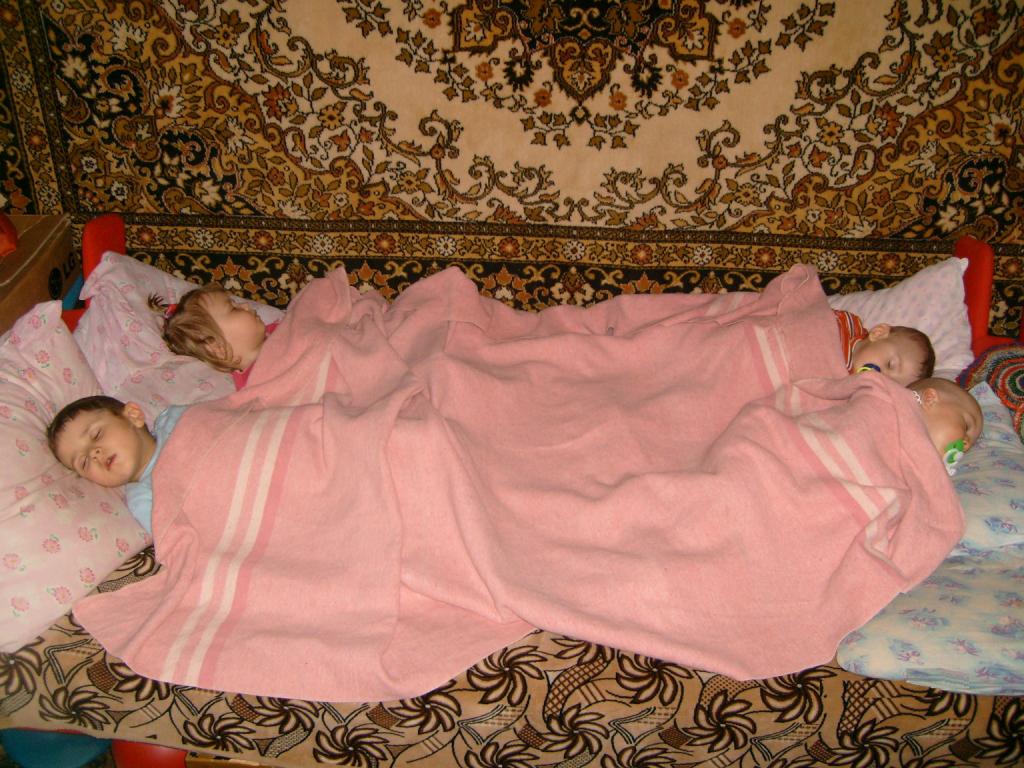Уложила 2 месячную дочку спать. Укрывает ребенка одеялом.