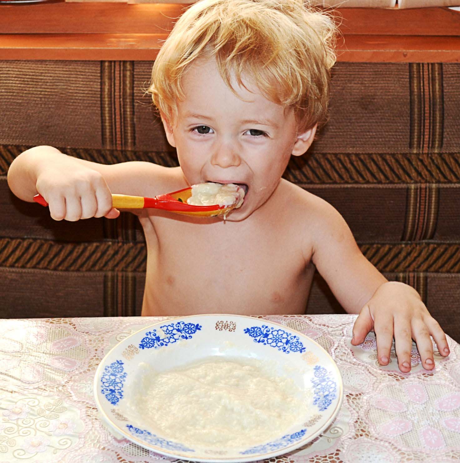 Если хотите стать сильными детки ешьте. Мальчик ест кашу. Кушать кашу. Ребенок завтракает. Дети за столом.