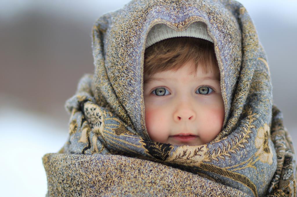 Ребенок в пуховом платке зимой
