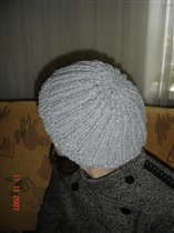 Берет сзади