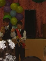 Глеб играет на трещётке на празднике первоклассника